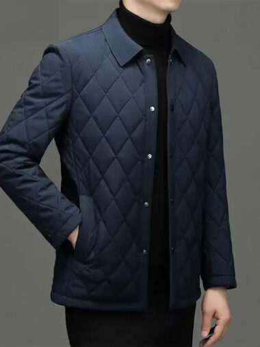 Veste matelassée homme avec col à revers bleu foncé. Portée par un homme, sur un fond gris foncé.