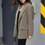 Veste blazer femme à double boutonnage, de couleur kaki, porté par une femme de profil.