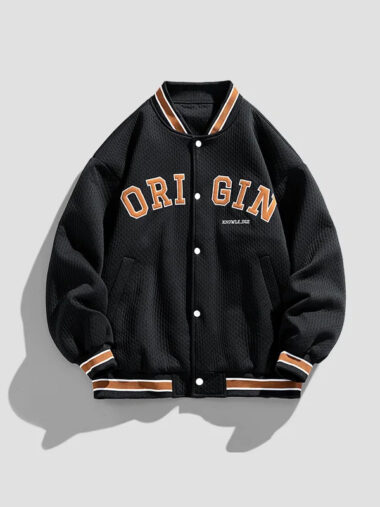 Veste universitaire noire pour femme avec lettres brodées en orange, sur un fond gris.