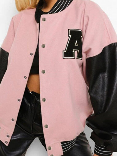 Veste universitaire femme style teddy oversize avec imprimé A, de couleur rose avec les manches noires, porté par une femme.