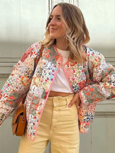 Veste patchwork femme conception matelassée avec imprimés fleuris avec boutonnage simple, porté par une femme, devant un mur.