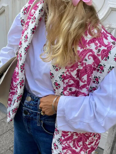 Veste sans manche femme avec imprimés de fleurs roses, porté par une femme.