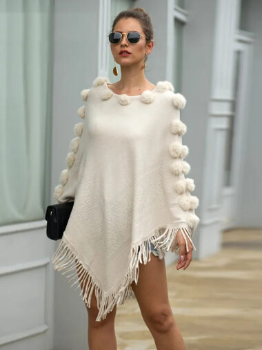Veste cape femme conception élégante à pompons, de couleur blanche, porté par une femme, dans la rue.