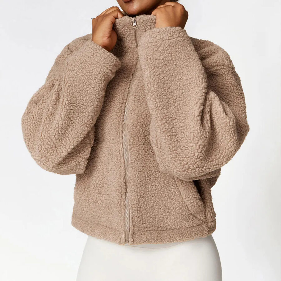 Veste pilou pilou femme avec col haut épais, de couleur marron, porté par une femme, sur un fond blanc.