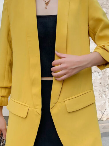 Veste 3/4 femme style blazer vintage, de couleur jaune, porté par une femme, en extérieur.