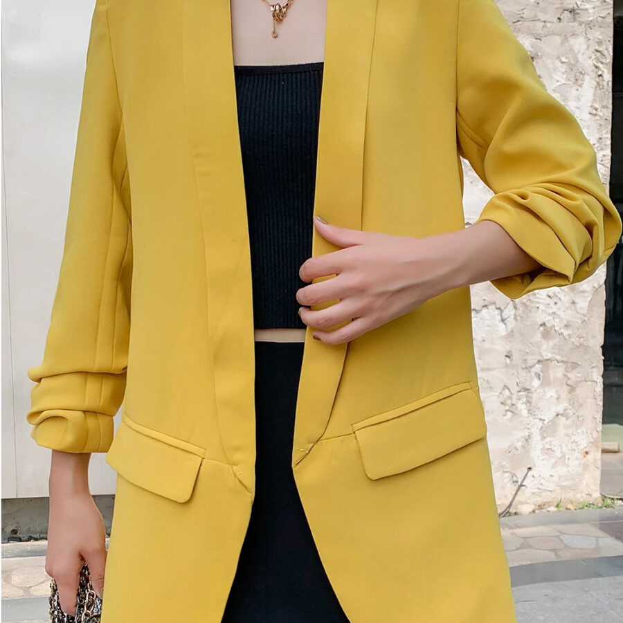 Veste 3/4 femme style blazer vintage, de couleur jaune, porté par une femme, en extérieur.
