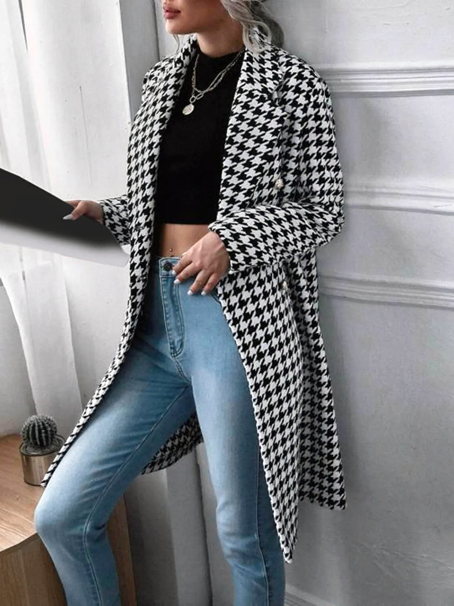 Veste pied de poule femme longue en coton à col rabattu Veste pied de poule femme longue en coton à col rabattu sur une femme en jean adossé à un mur