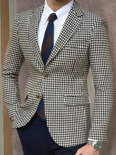 Veste pied de poule homme élégante noire et blanche, porté par un homme, devant un mur.