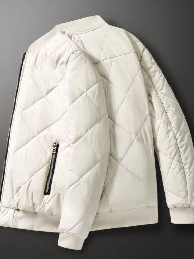 Veste teddy homme matelassée et épaisse, de couleur blanche. Sur un fond gris et noir.