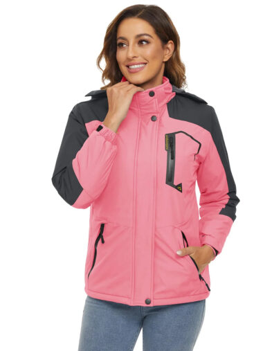 Veste randonnée femme conception thermique et imperméable, de couleur rose, porté par une femme, sur un fond blanc.