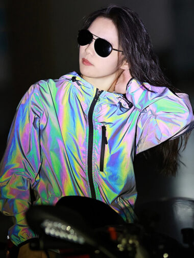Veste réfléchissante femme imperméable avec capuche, de couleur arc-en-ciel, porté par une femme.