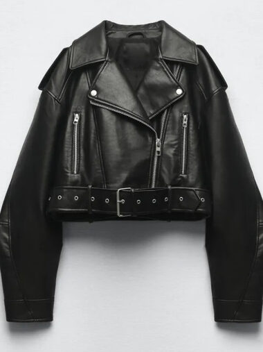 Veste courte femme style perfecto en simili cuir, de couleur noire, sur un fond gris.