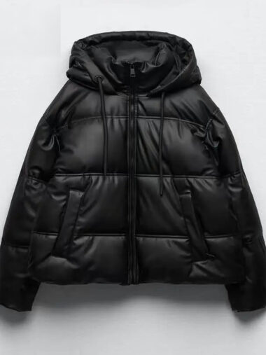 Veste matelassée femme conception en simili cuir avec capuche, de couleur noire, sur un fond gris.