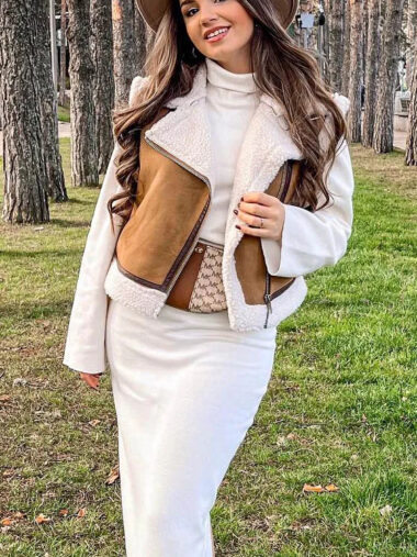 Veste mouton femme avec col à revers élégant, veste sans manche, de couleur marron porté par une femme dans une forêt.