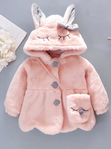 Veste bébé fille avec capuche en forme de lapin sur fond gris avec des étoiles des fleurs et un magazine