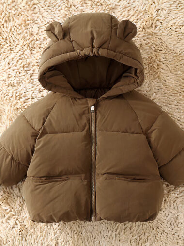 Veste garçon bébé de style doudoune avec capuche à oreilles sur fond beige