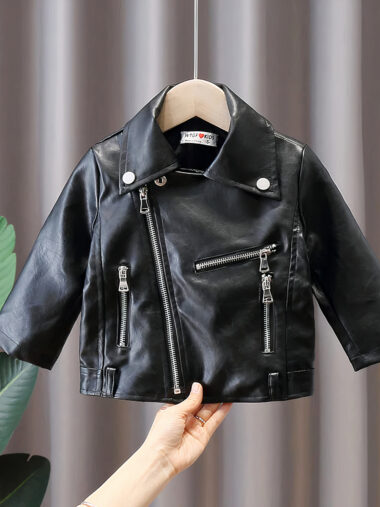 Veste bébé garçon design en simili cuir suspendu avec une main en dessous et une plante verte à gauche