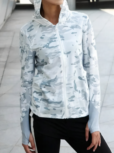 Veste de chasse femme effet camouflage militaire portée par une femme avec un pantalon noir dans la rue