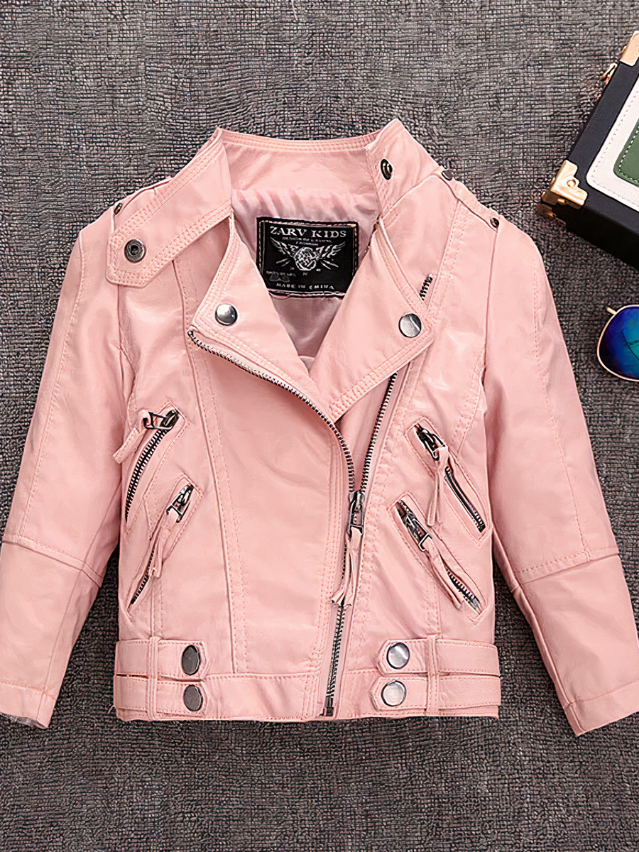 Veste fille en simili cuir avec fermeture éclair Veste fille en simili cuir avec fermeture éclair sur fond gris avec une paire de lunettes et une boîte à droite