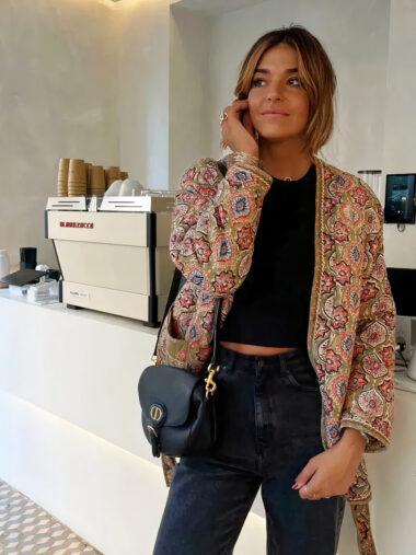 Veste patchwork matelassée avec imprimés fleuries, de couleur multicolore, porté par une femme, devant un comptoir dans un café.