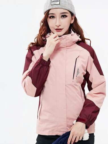 Veste randonnée femme conception amovible et imperméable, de couleur rose, porté par une femme, sur un fond blanc.