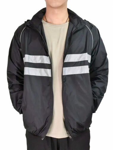 Veste réfléchissante homme coupe-vent avec capuche, de couleur noire, porté par un homme.